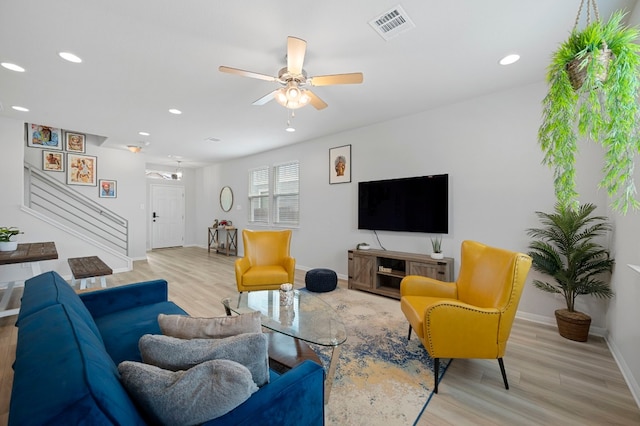 living room with light hardwood / wood-style flooring and ceiling fan