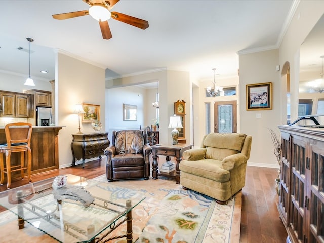 living room featuring ceiling fan with notable chandelier, dark wood-type flooring, and ornamental molding