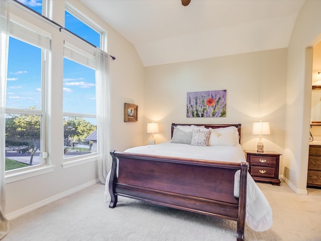 bedroom with light colored carpet and vaulted ceiling