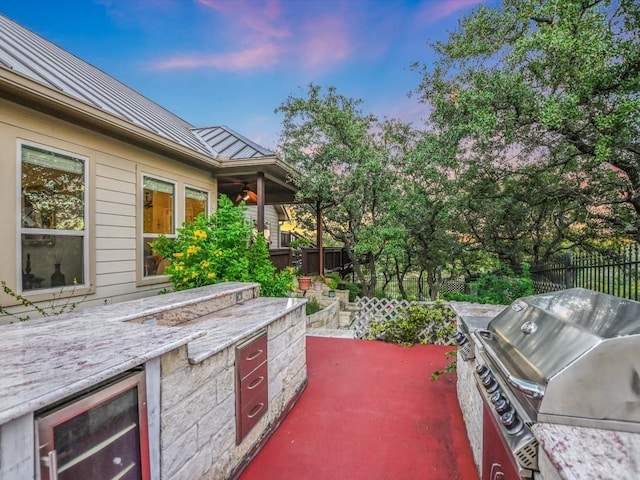 717 Fallow, Horseshoe Bay, TX 78657 - patio terrace at dusk featuring wine cooler, an outdoor kitchen, and a patio area