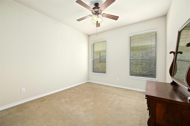 unfurnished room featuring plenty of natural light, ceiling fan, and light colored carpet