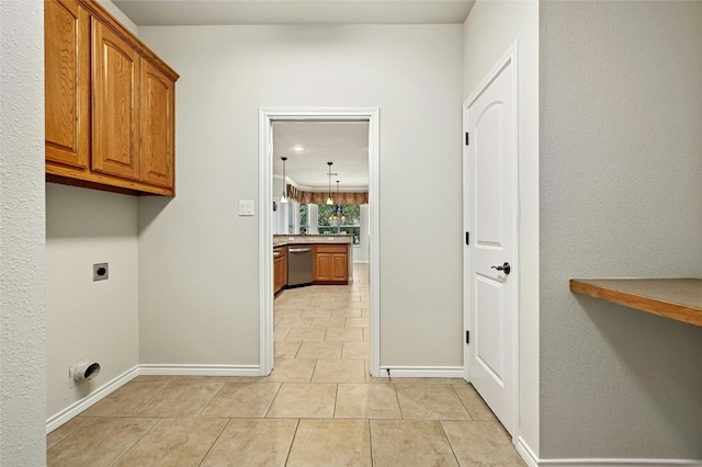 laundry room featuring light tile patterned floors, hookup for an electric dryer, and cabinets