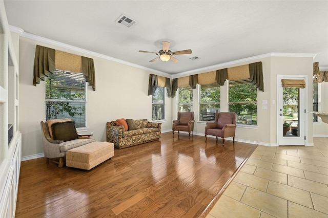 living room with wood-type flooring, ornamental molding, and ceiling fan