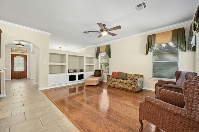 living room with ceiling fan, ornamental molding, and light hardwood / wood-style flooring