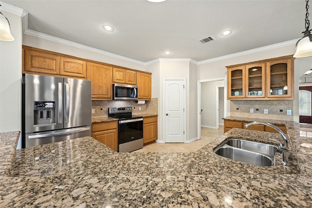 kitchen with decorative light fixtures, light tile patterned floors, appliances with stainless steel finishes, sink, and dark stone countertops