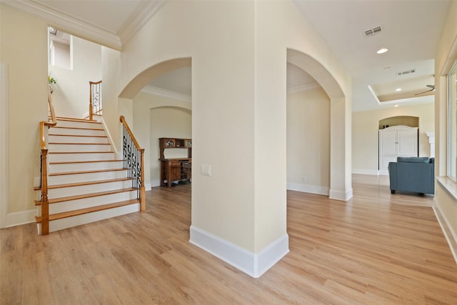 foyer entrance featuring crown molding and light wood-type flooring