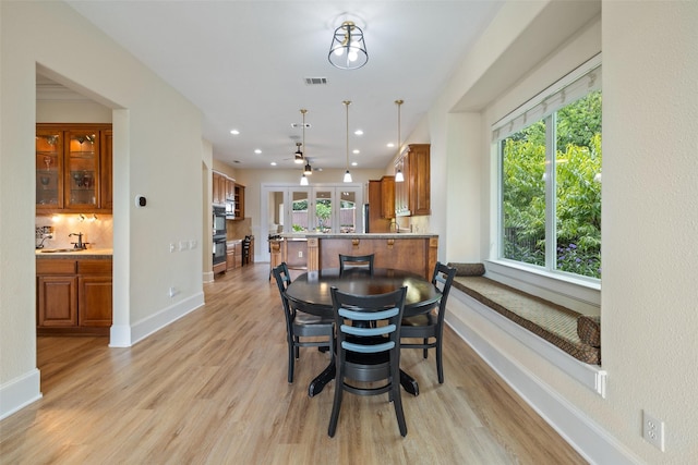 dining room with sink and light wood-type flooring