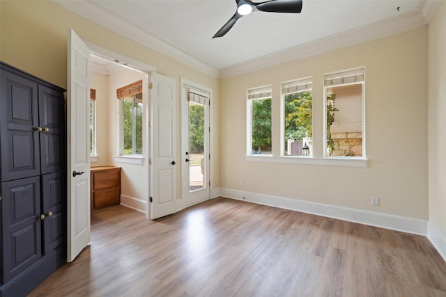 interior space featuring ornamental molding, ceiling fan, and light wood-type flooring