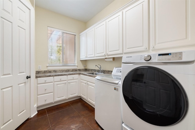 laundry room featuring cabinets, washer and clothes dryer, sink, and dark tile patterned flooring