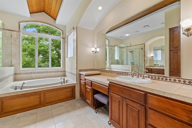 bathroom with vaulted ceiling, shower with separate bathtub, decorative backsplash, vanity, and tile patterned floors