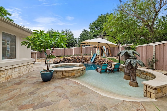 view of patio / terrace featuring a swimming pool with hot tub