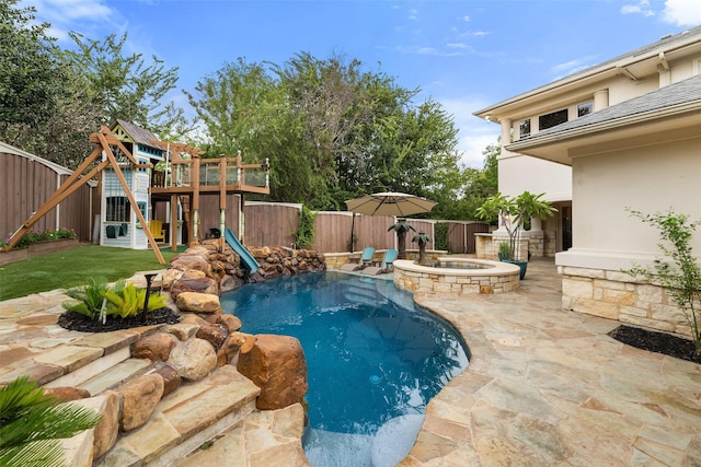 view of swimming pool with a playground, an in ground hot tub, and a patio area