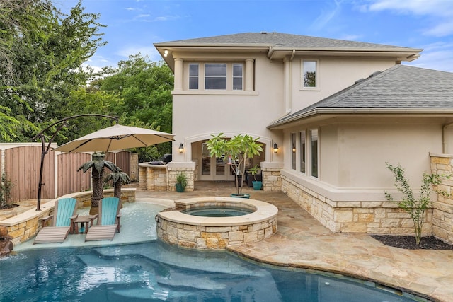 rear view of house with a swimming pool with hot tub, an outdoor bar, and a patio area