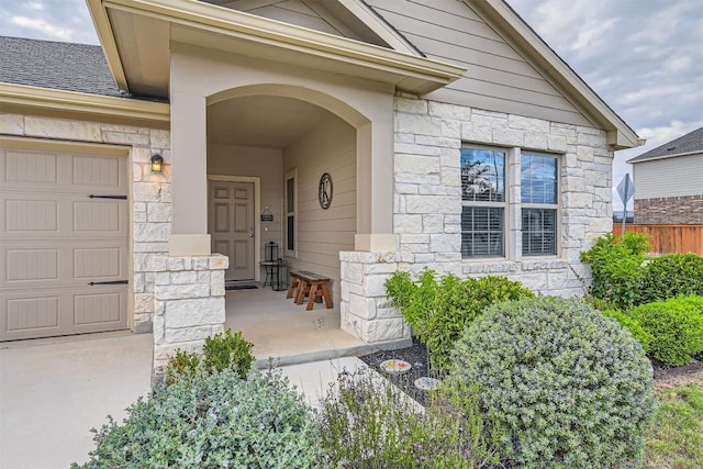 entrance to property featuring a porch and a garage