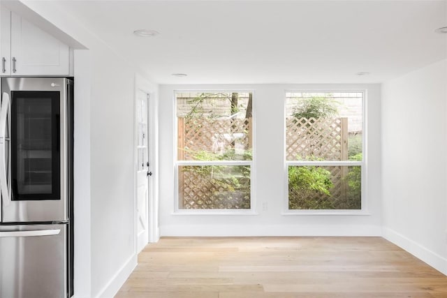 interior space featuring white cabinetry, stainless steel refrigerator, and light hardwood / wood-style floors