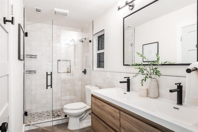 bathroom with decorative backsplash, vanity, tile walls, toilet, and a shower with shower door