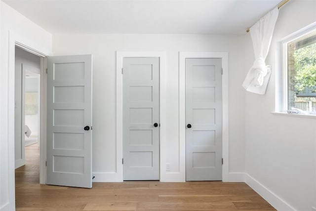 interior space with multiple closets and light hardwood / wood-style floors