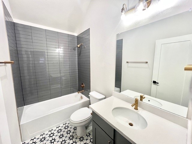 full bathroom with toilet, vanity, and tiled shower / bath