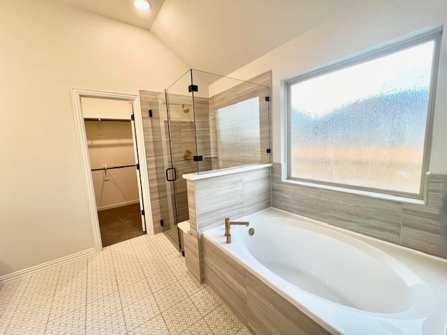 bathroom featuring separate shower and tub and vaulted ceiling