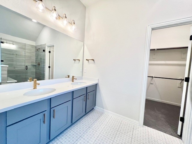 bathroom with vanity, vaulted ceiling, and a shower with door