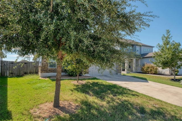 obstructed view of property featuring a garage and a front yard