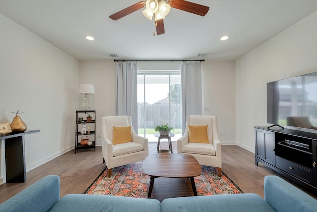 living room featuring ceiling fan and light hardwood / wood-style floors