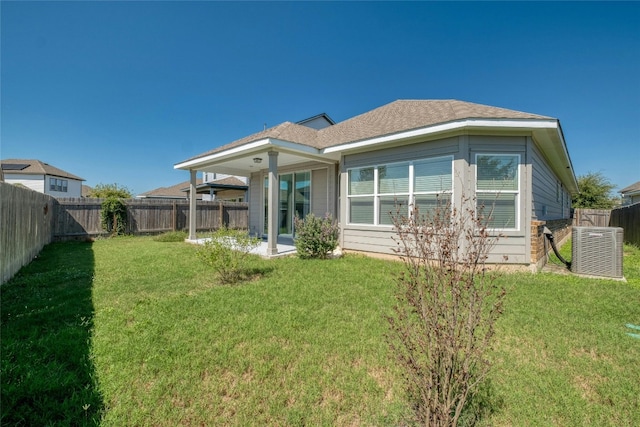 rear view of property with a yard, cooling unit, and a patio area