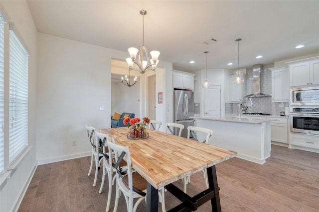 dining room featuring light hardwood / wood-style flooring, a chandelier, and a healthy amount of sunlight