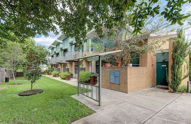 view of front of house featuring a balcony and a front yard