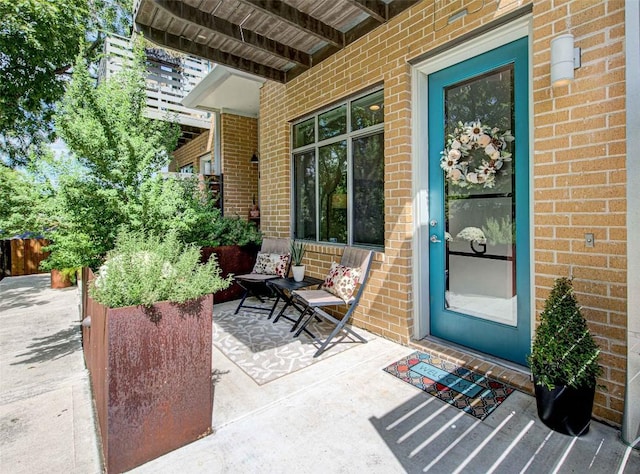 property entrance with brick siding and fence