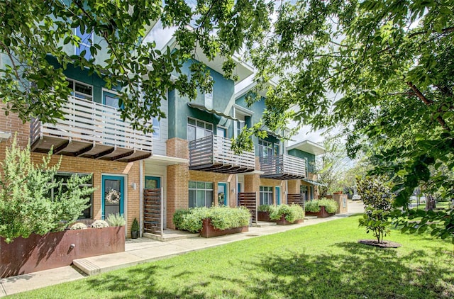 rear view of property with a lawn and a balcony