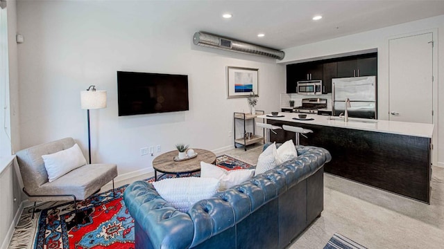 living room with recessed lighting, baseboards, and light colored carpet