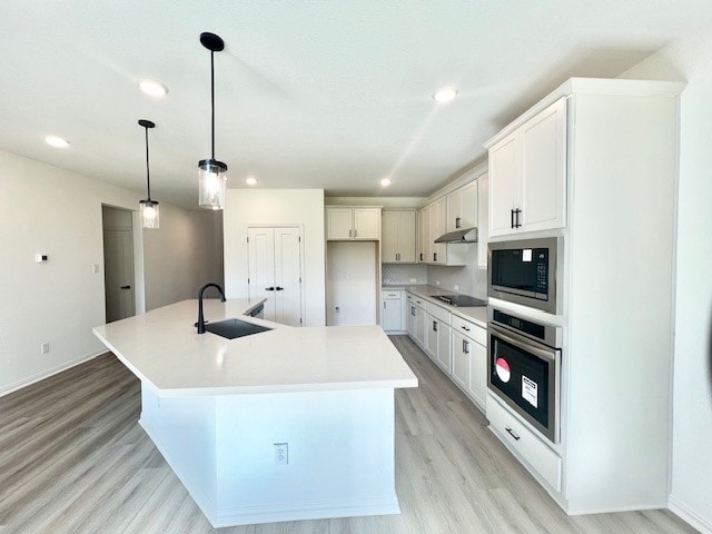 kitchen featuring a center island with sink, appliances with stainless steel finishes, sink, light hardwood / wood-style floors, and white cabinets