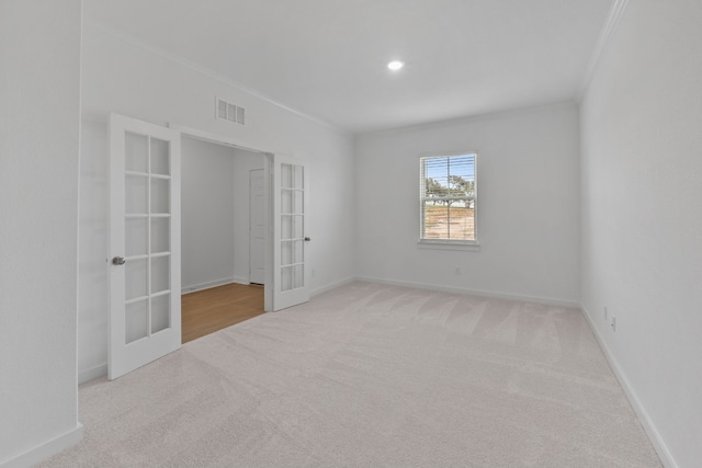 carpeted empty room with french doors and ornamental molding