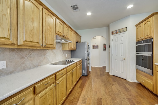 kitchen featuring light hardwood / wood-style flooring, stainless steel appliances, and tasteful backsplash