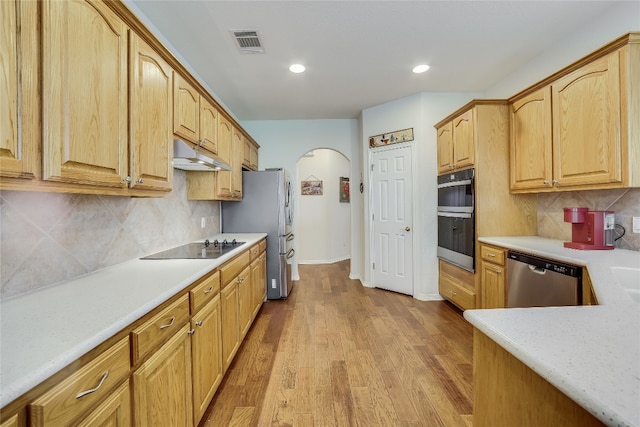 kitchen featuring light hardwood / wood-style flooring, stainless steel appliances, and backsplash