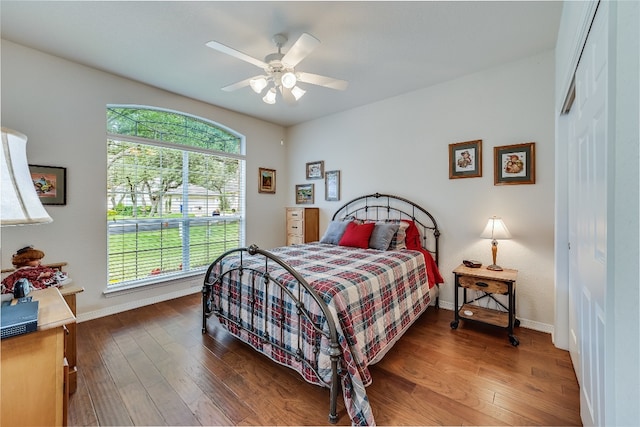 bedroom with dark hardwood / wood-style flooring, ceiling fan, and a closet