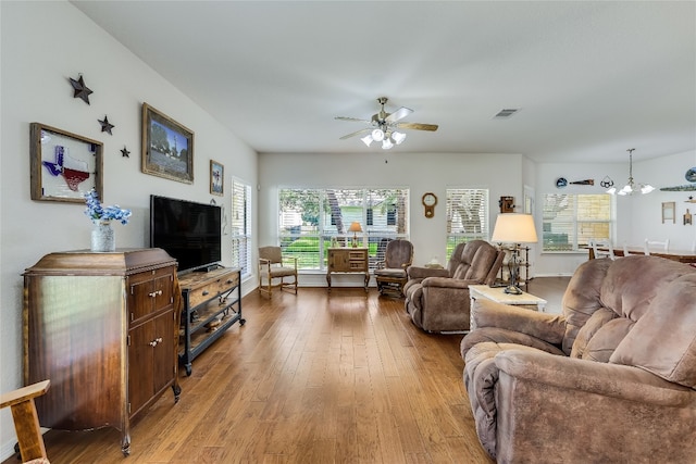 living room with light hardwood / wood-style flooring and ceiling fan with notable chandelier