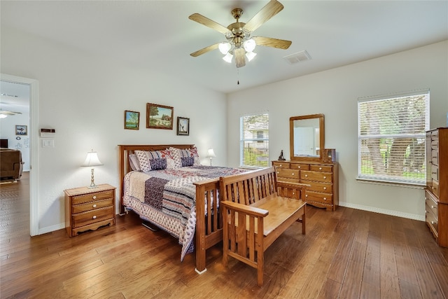 bedroom featuring multiple windows, hardwood / wood-style flooring, and ceiling fan