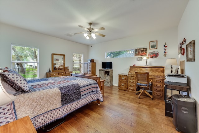 bedroom featuring multiple windows, ceiling fan, and wood-type flooring