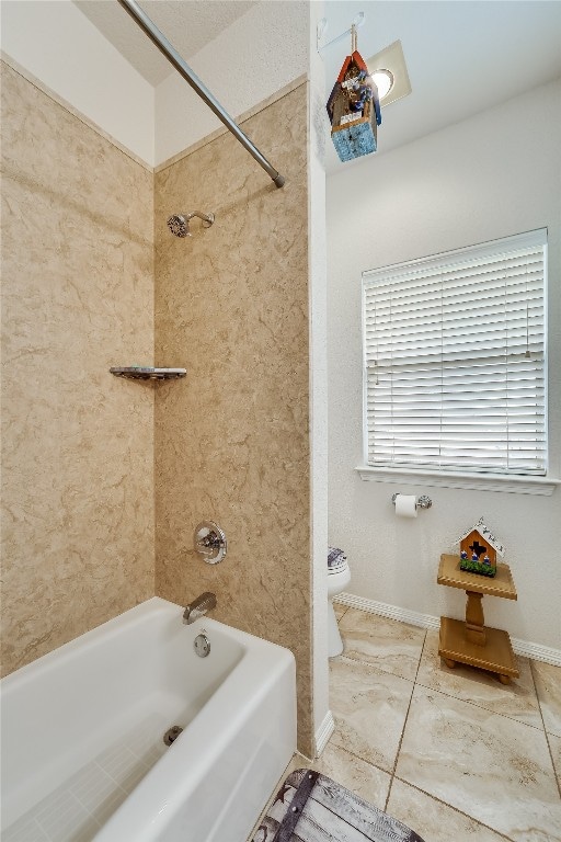 bathroom featuring toilet, tile patterned floors, and tiled shower / bath