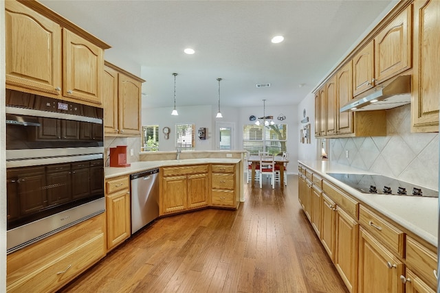 kitchen with pendant lighting, light hardwood / wood-style flooring, backsplash, stainless steel appliances, and kitchen peninsula