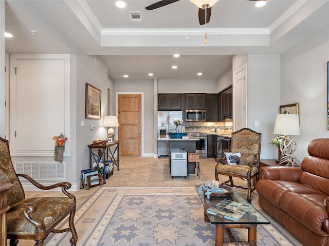 living room with ornamental molding, a raised ceiling, and ceiling fan