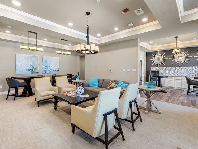 carpeted living room with a tray ceiling, ornamental molding, and a chandelier