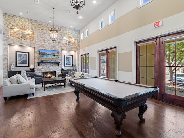 rec room with a fireplace, a towering ceiling, pool table, and dark hardwood / wood-style floors