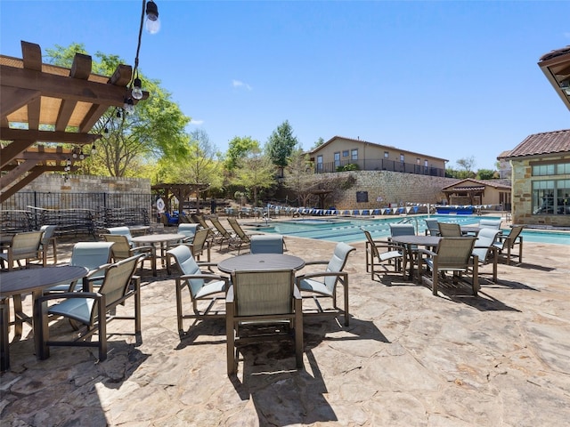 view of patio / terrace featuring a community pool and a pergola