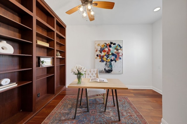 unfurnished office with ceiling fan and dark hardwood / wood-style flooring