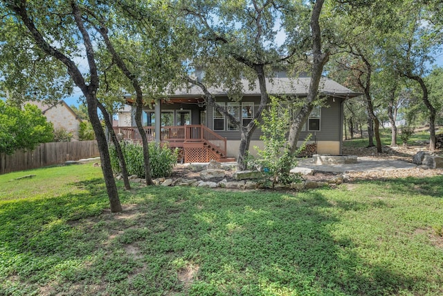 rear view of house with a deck and a yard