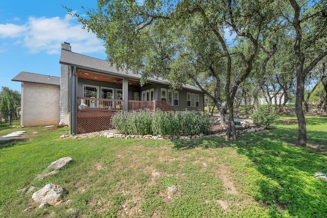 rear view of property featuring a deck and a yard