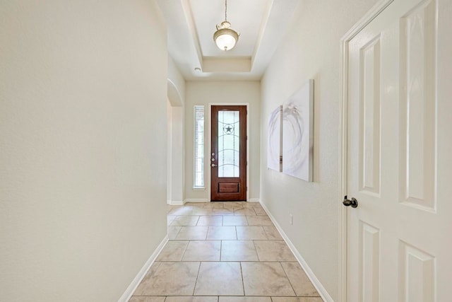 entrance foyer featuring a raised ceiling and light tile patterned flooring